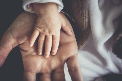 Photo représentant une main de bébé et une main d'adulte